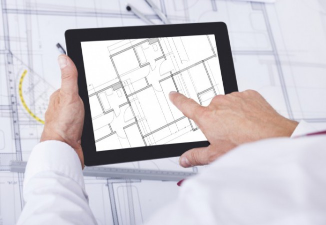 Close-up Of Male Architect Analyzing Blueprint Over Digital Tablet